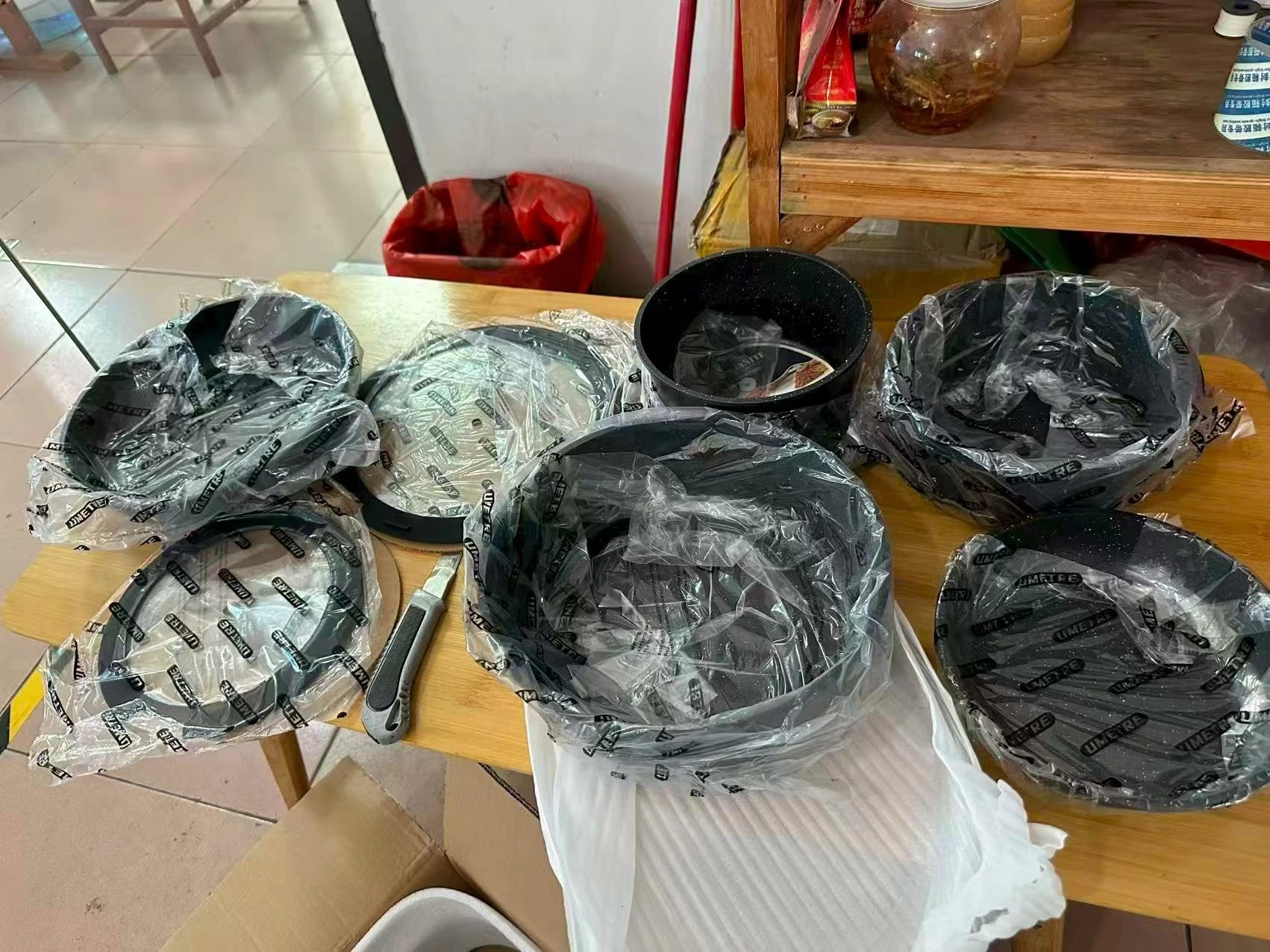 Кастрюли, сковороды и крышки в защитной упаковке на столе